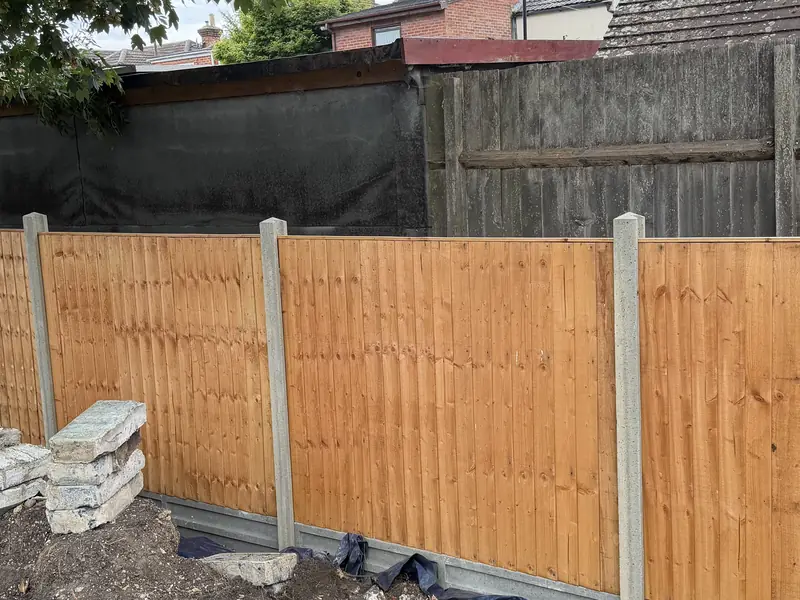 New featheredge fence panels between concrete posts with concrete gravel boards